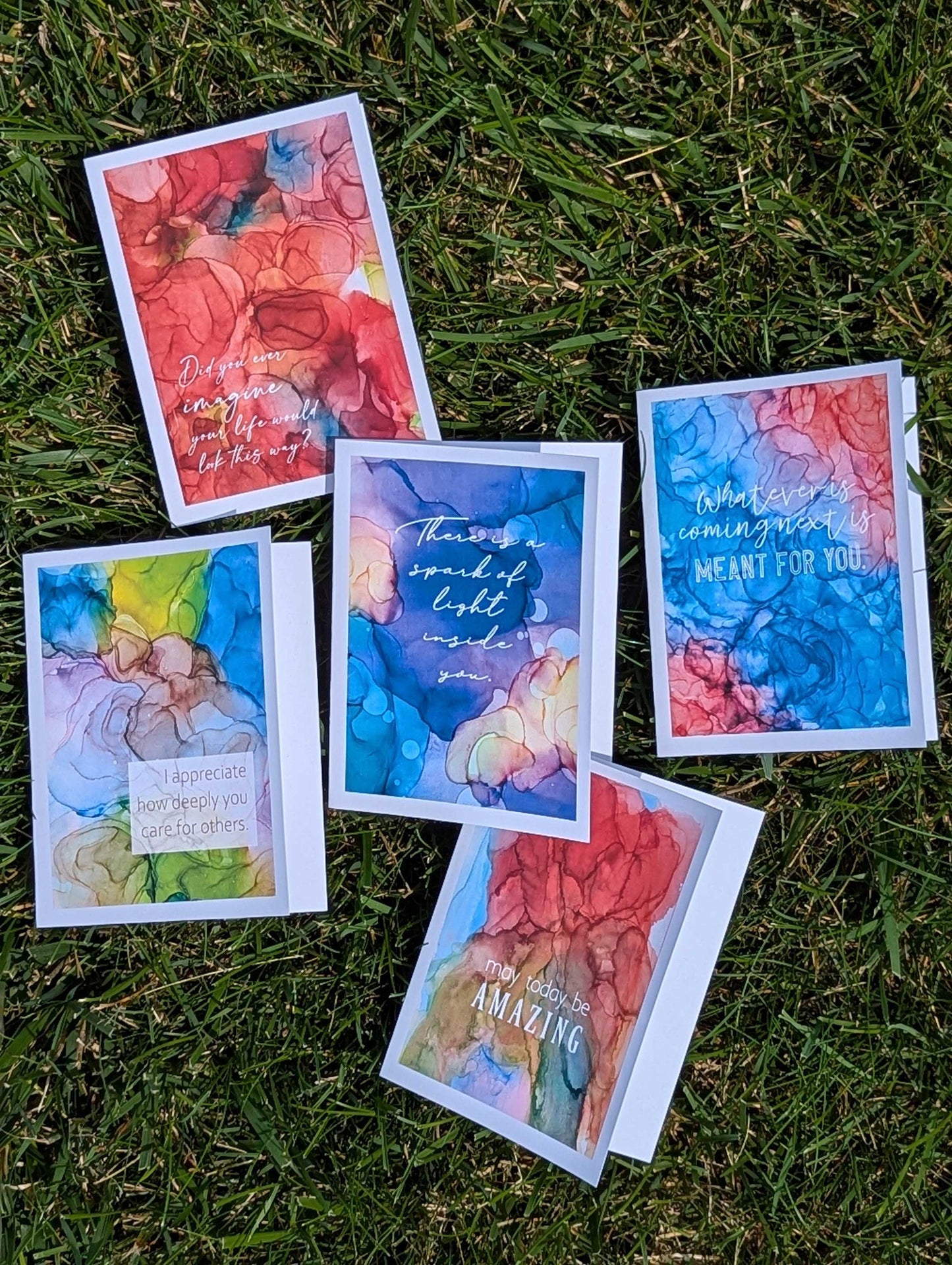 Colorful greeting cards with motivational messages on a grassy background