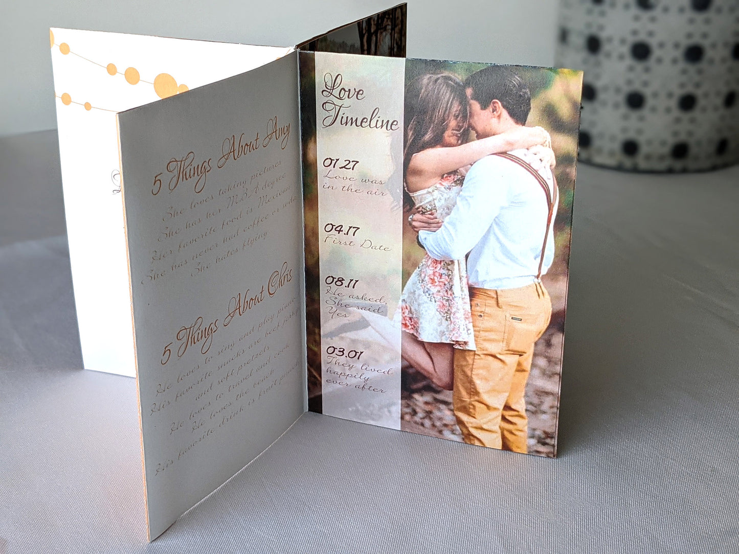 Centerpiece sitting on a white background with panels showing fun facts about the couple, an engagement photo with their heads together, and a timeline of their relationship.
