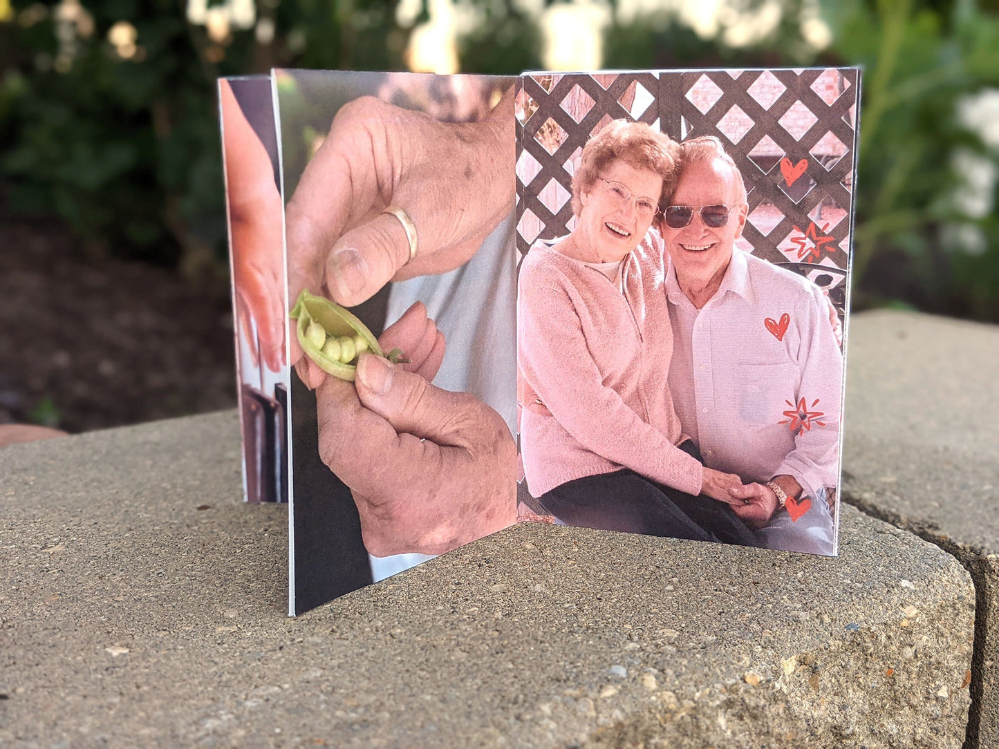 Centerpiece sitting on a landscape stone showing an older couple looking at the camera and a wrinkled pair of hands shelling peas.