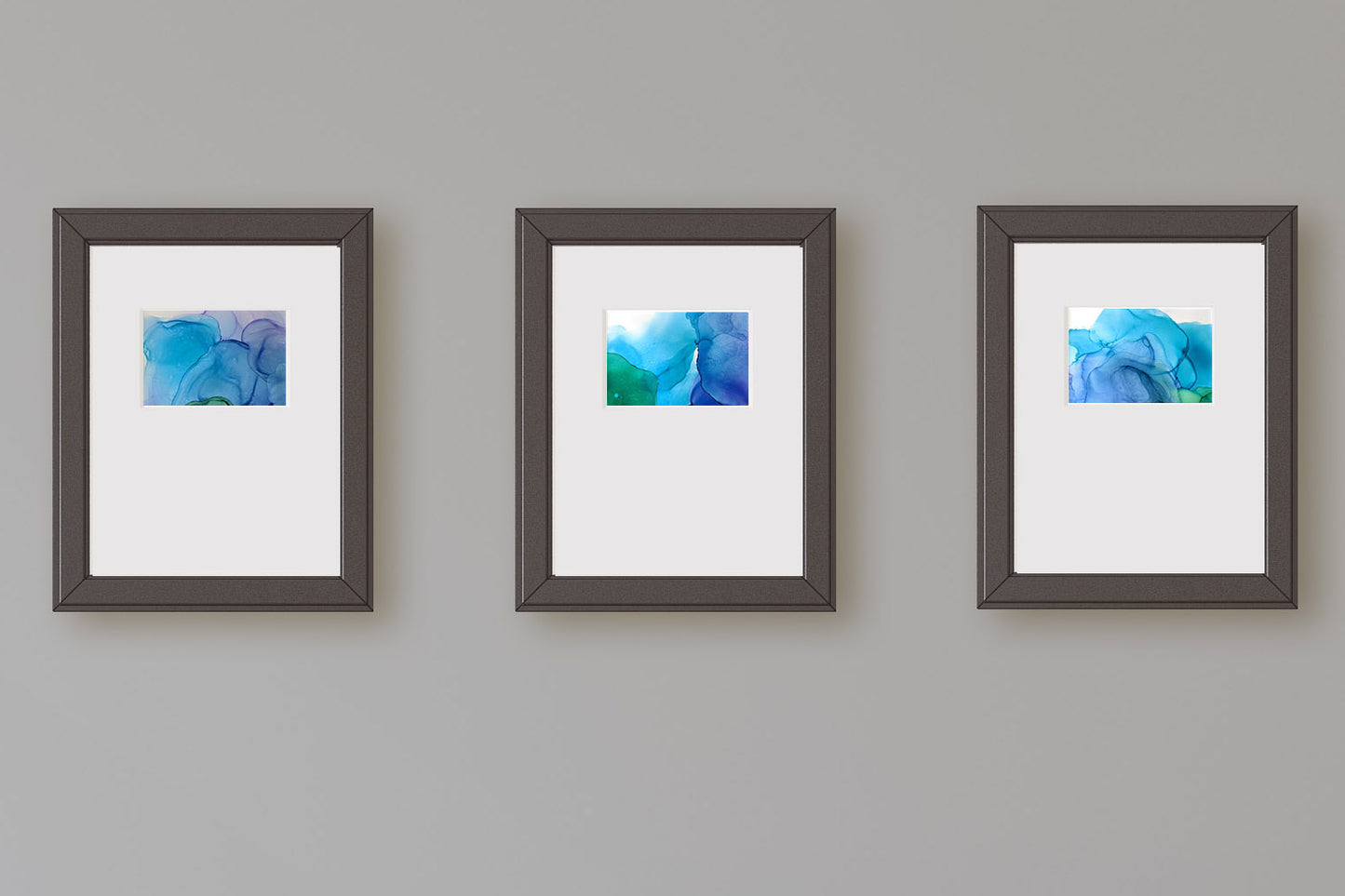 Zoomed in view of three paintings framed in black hung on a grey wall.