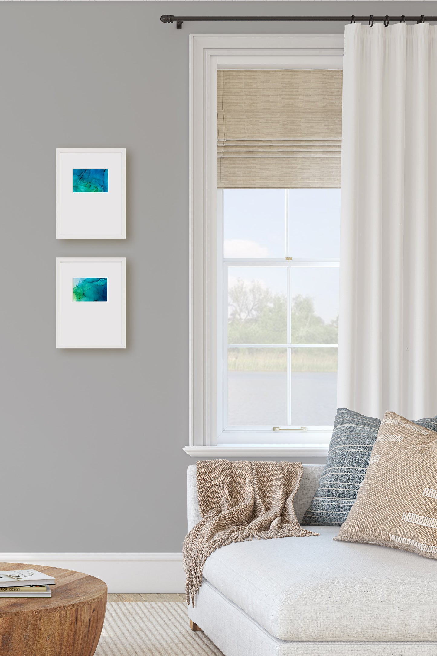 Digital mockup of two paintings hanging near a window and sofa in a family room.