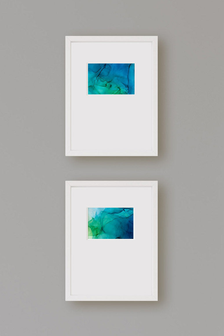 Zoomed in view of two paintings framed in white.
