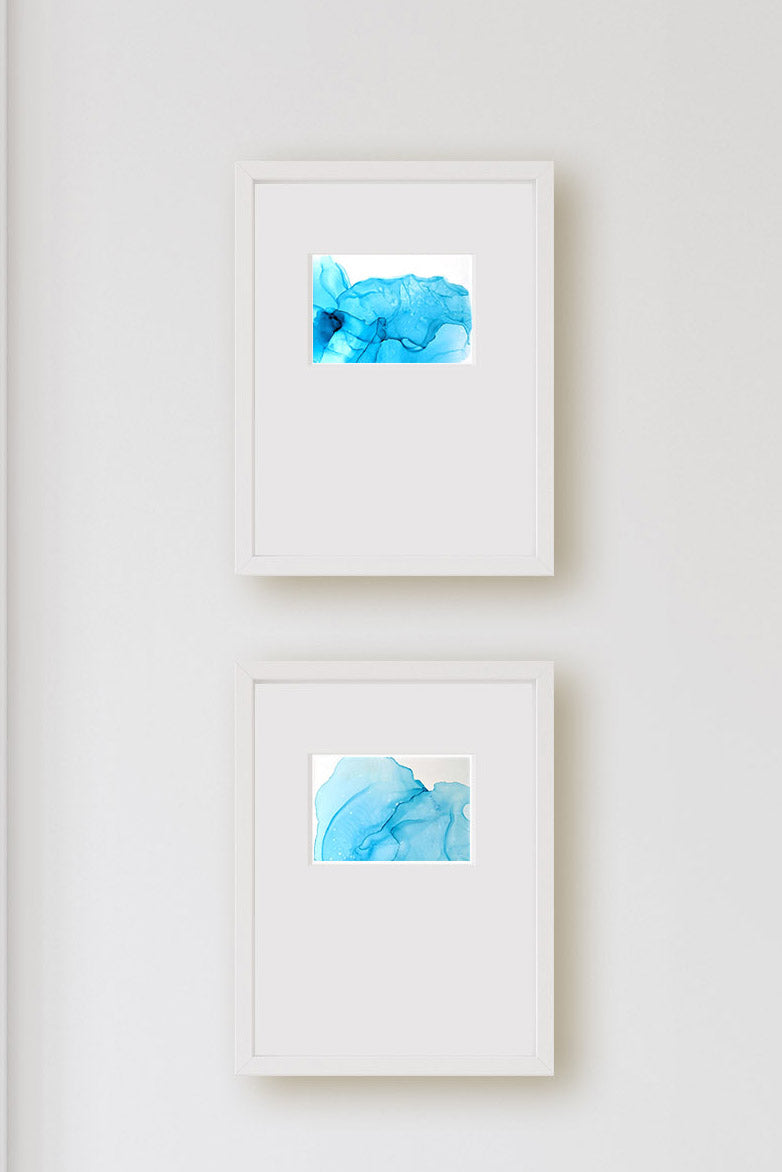 Zoomed in detail of two paintings on a light grey wall.
