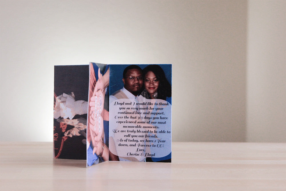 Centerpiece standing on a wooden table top with a panel showing the couple standing together looking at the camera with the wording of a thank you note collaged over the photo.