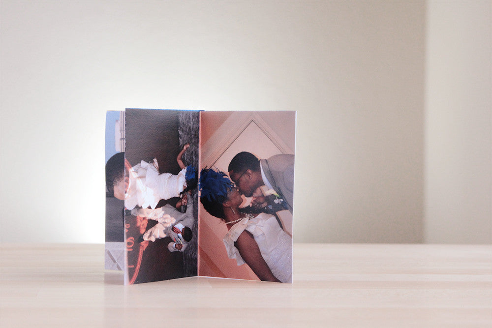 Centerpiece standing on a wooden table showing the couple in their wedding attire dancing and kissing.