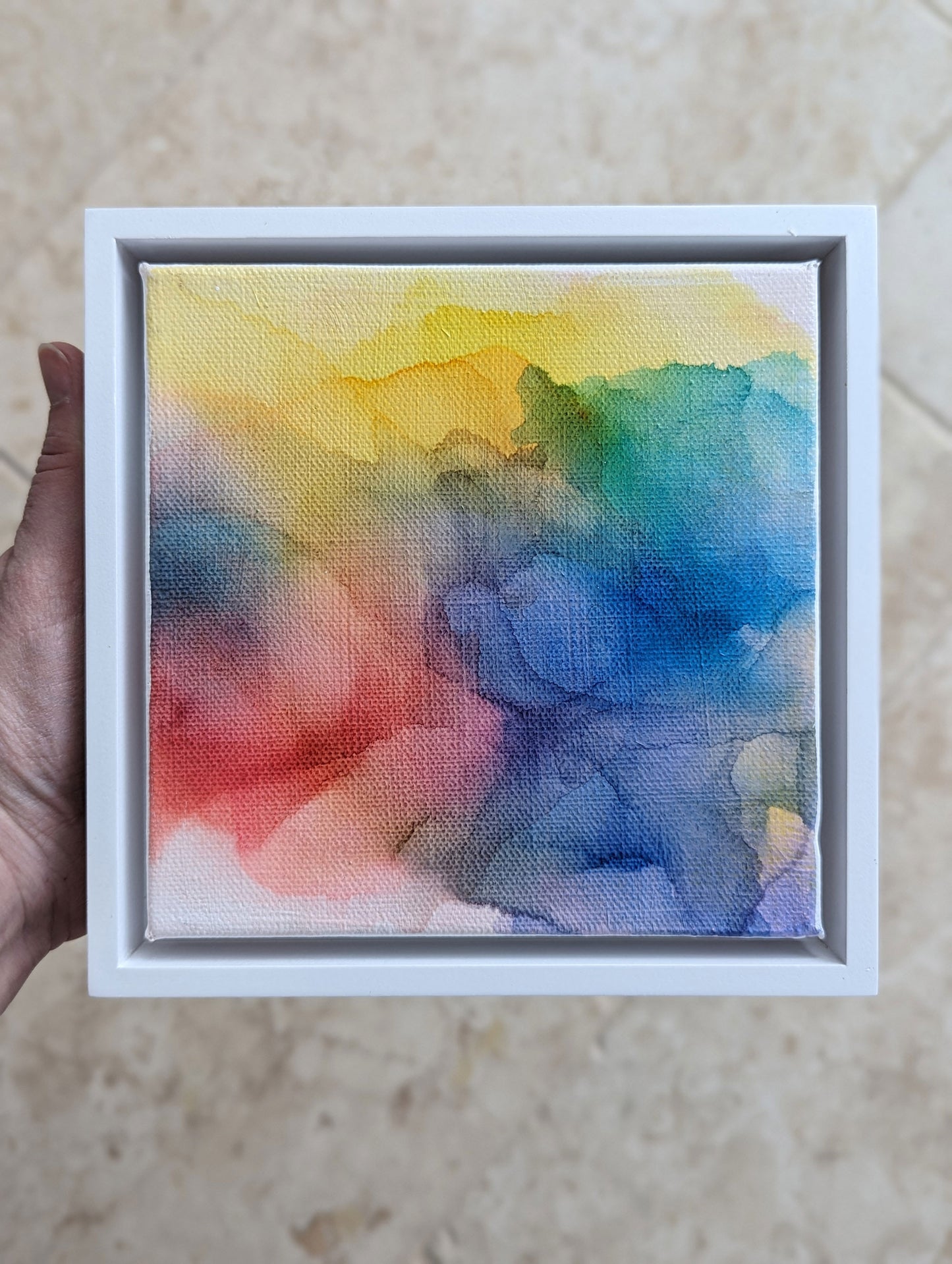 Hand holding the white float framed Possibilities of Hope indoors.