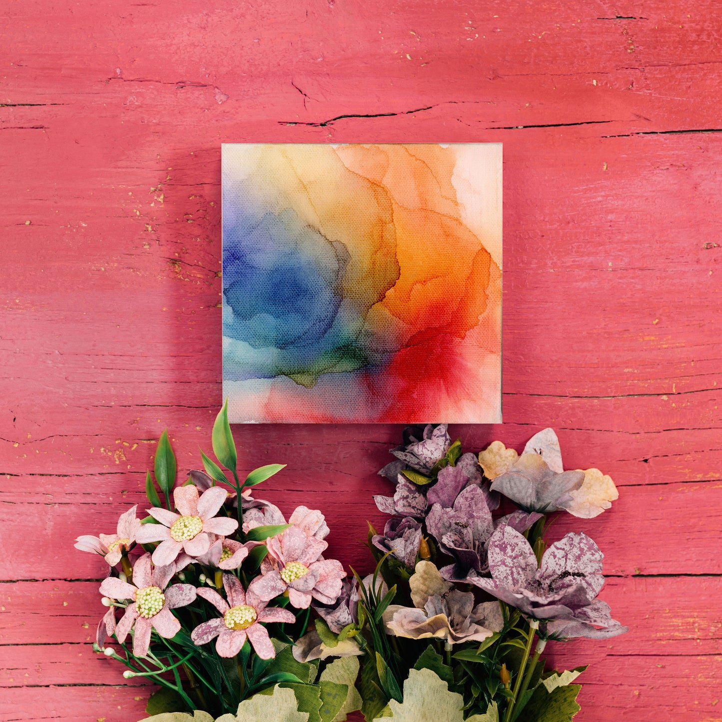 Digital mockup of the canvas laying on red painted boards above stems of flowers.