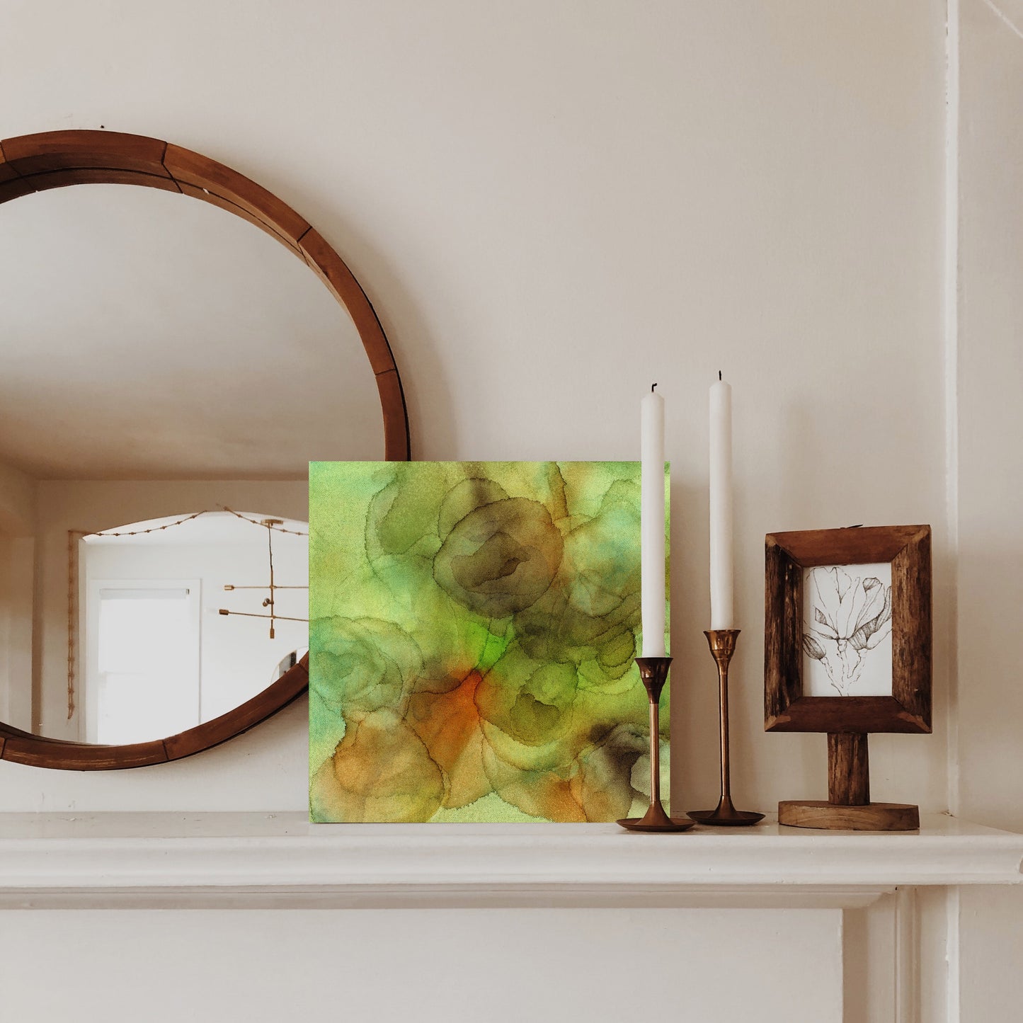 Digital mockup of Backwoods set on a neutral fireplace mantel surrounded by a circular framed mirror, candlesticks and a wooden frame.