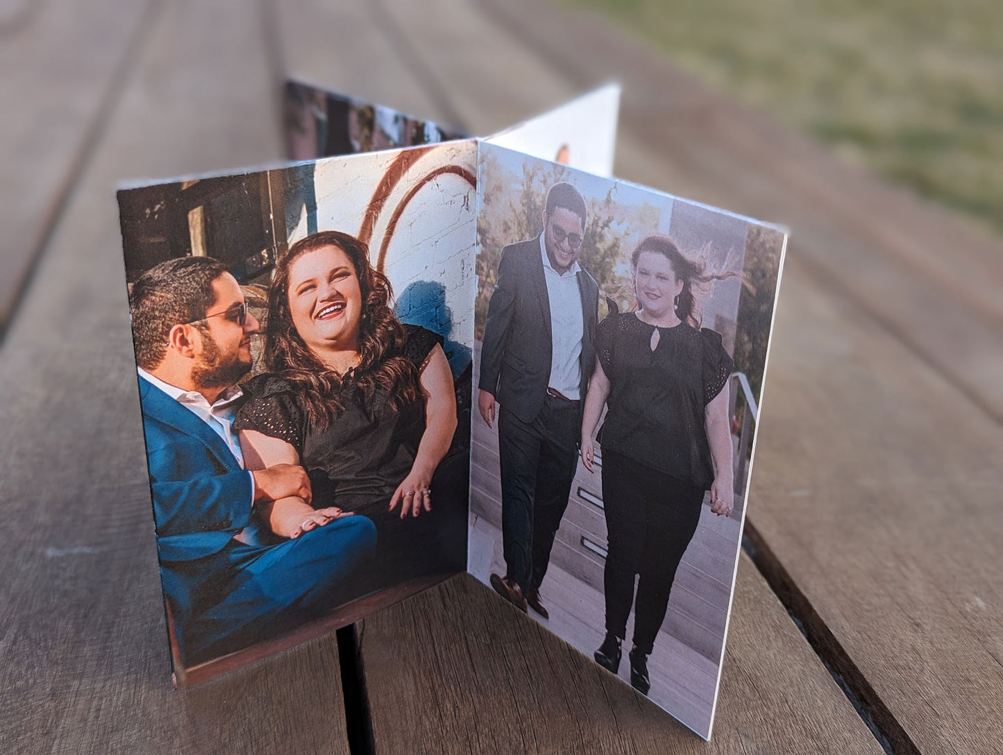 Centerpiece sitting on wooden boards showing a couple walking toward the camera and the couple sitting together smiling.