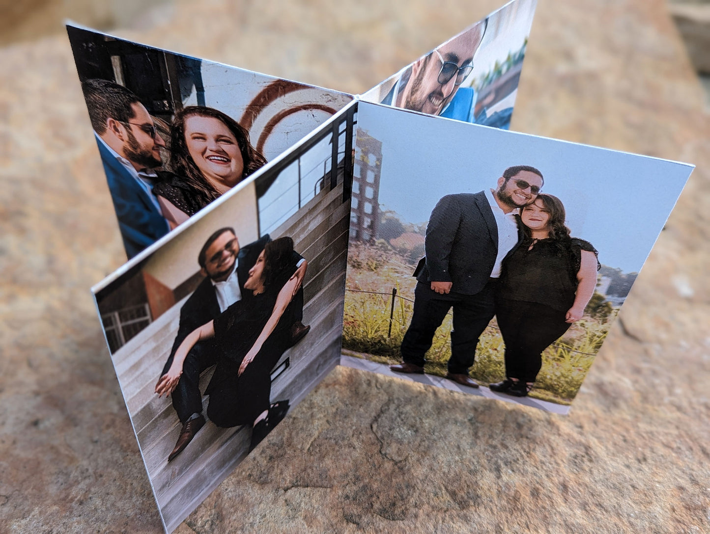 Overhead view of a centerpiece showing a couple smiling at each other sitting on steps and leaning their heads together smiling at the camera, sitting on a stone.