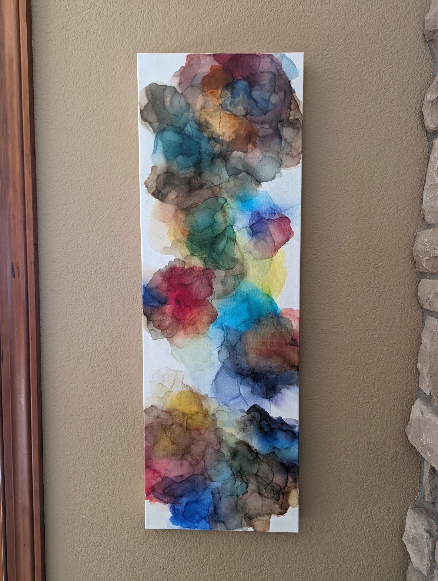 Vertical orientation of Expanding Boundaries hanging on a tan wall indoors.