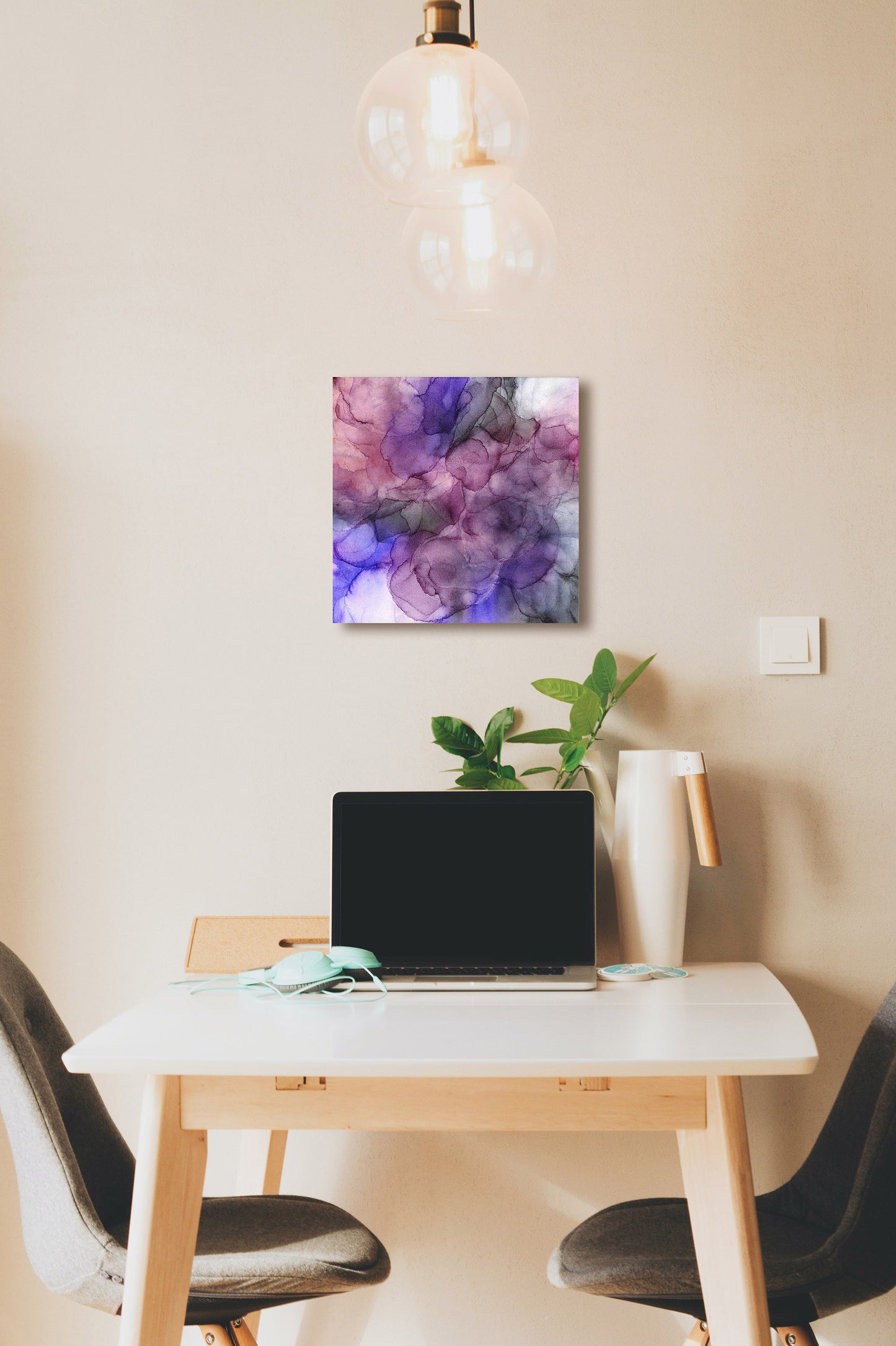 Digital mockup of Flow hung on a wall above a desk where a laptop, headphones, green plant and pitcher are sitting. Chairs sit on either side of the table.