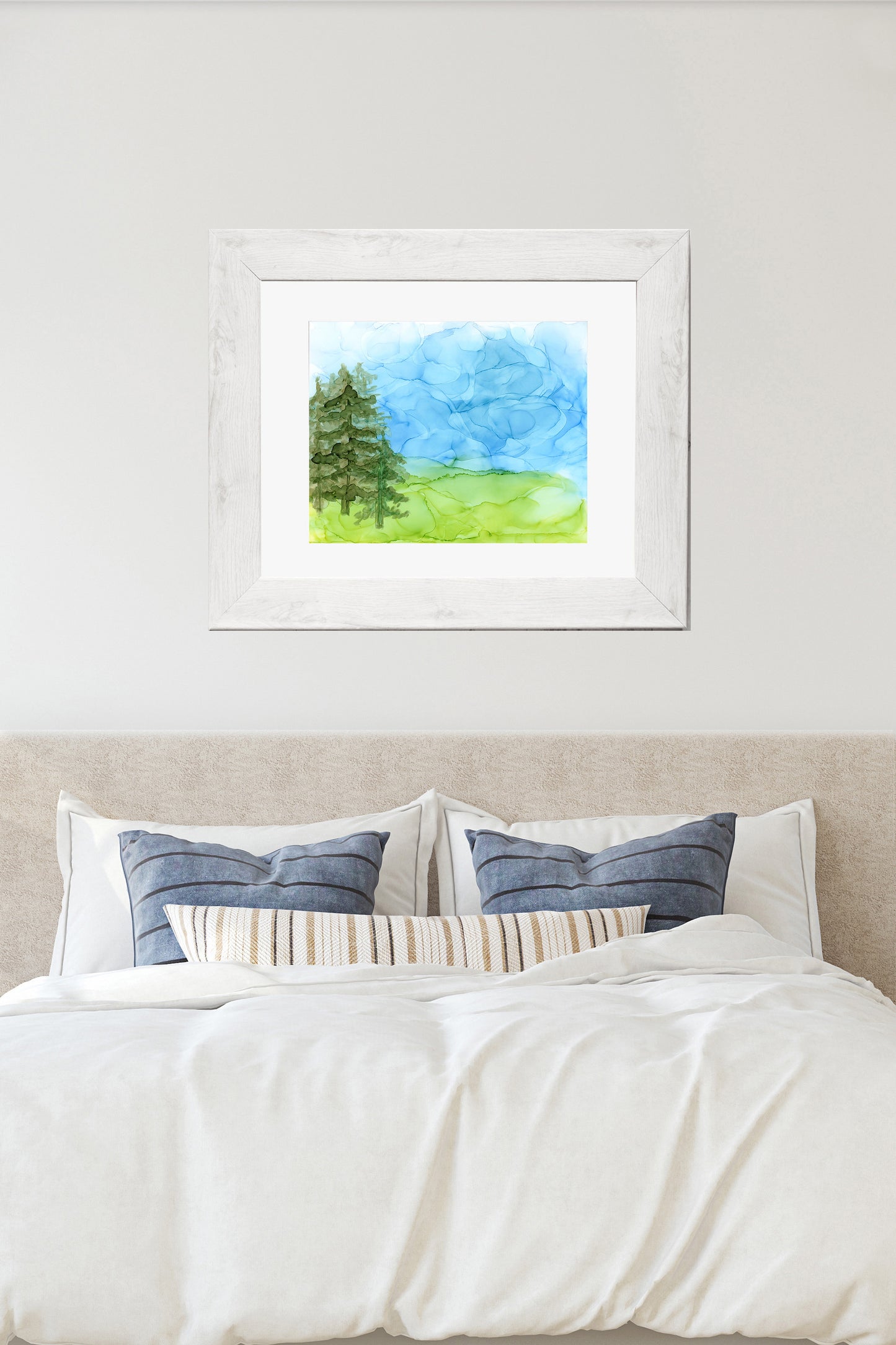 Digital mockup showing Free to Wonder framed in whitewashed wood hung over a bed against a neutral wall.