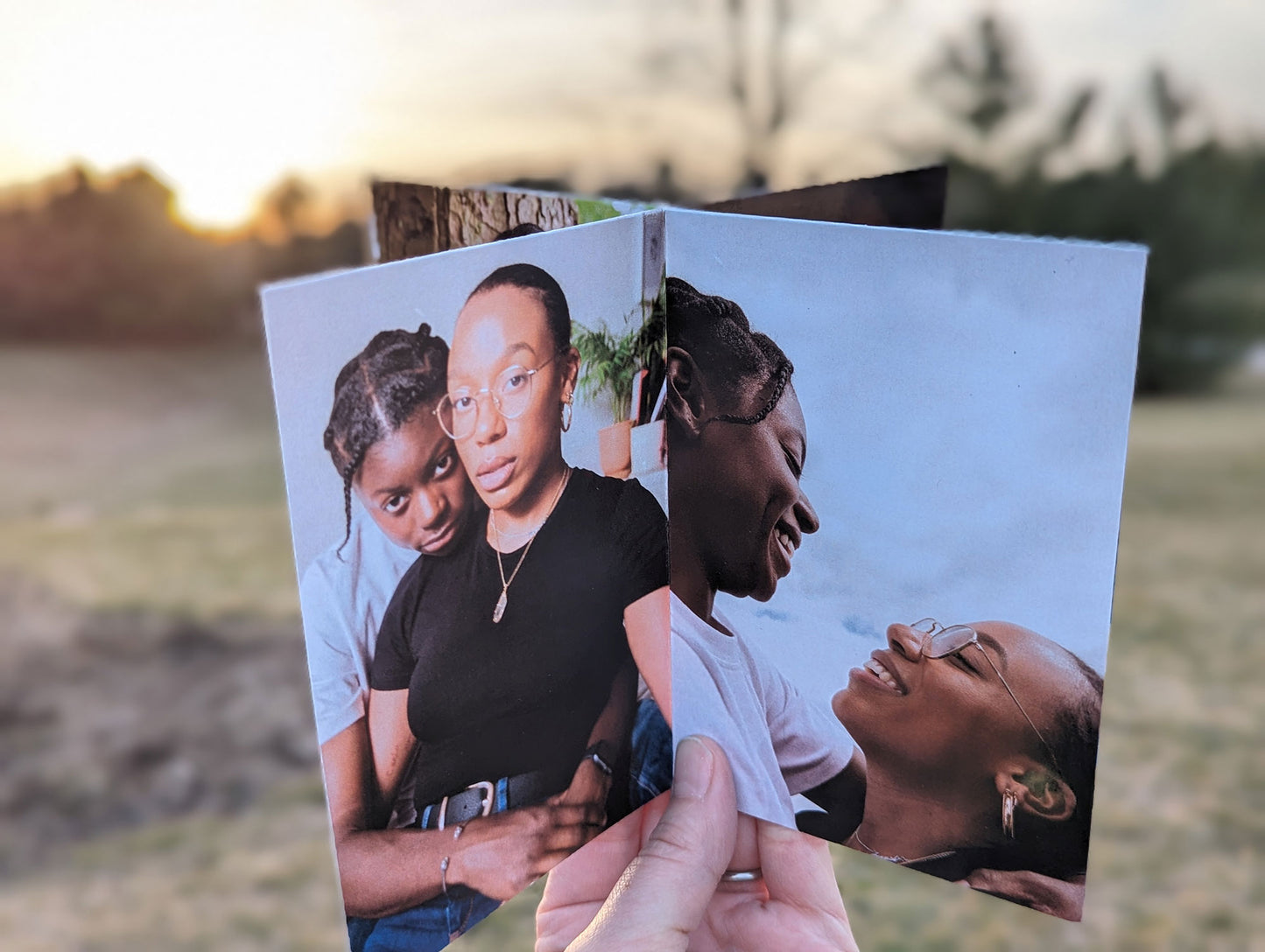 Centerpiece outdoors with an evergreen background showing panels of an LGBTQ+ couple looking at the camera and smiling at each other.
