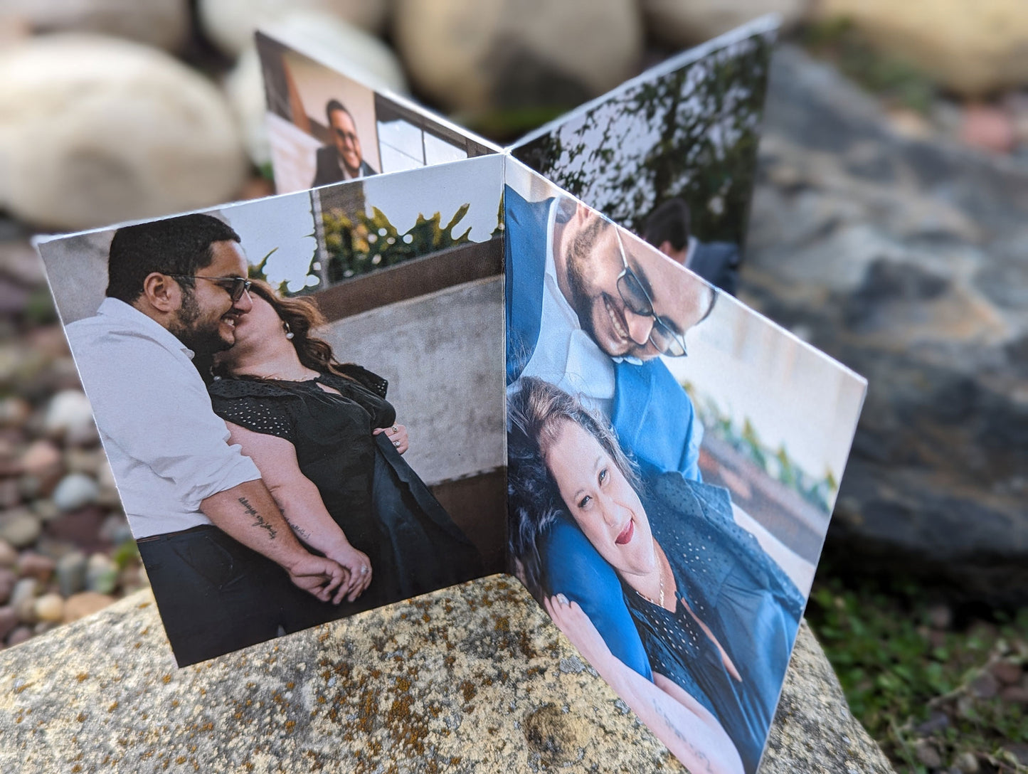 Centerpiece among the rocks with engagement photos. The panels show a partner kissing the other on the cheek and one with their head on the other's knee smiling into the camera.