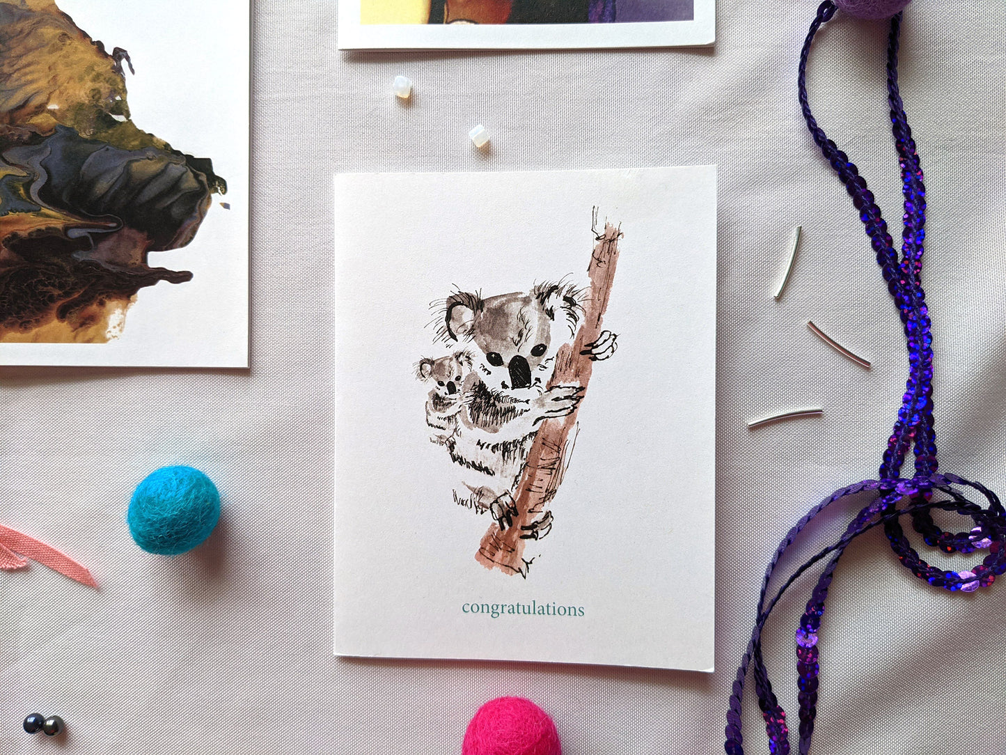 Greeting cards on a white background with sequins, colorful felt balls, tiny beads and colorful cotton ribbon.