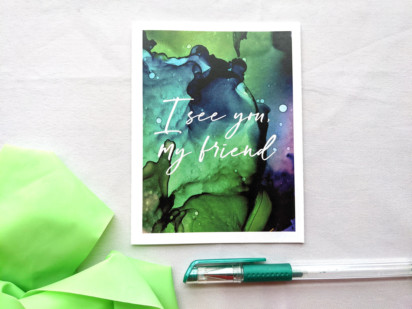 Greeting card on a white background with colorful stretch band and pen.