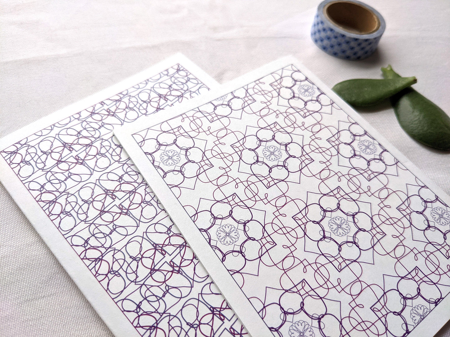 Angled view of two greeting cards and succulent leaves forming a heart.