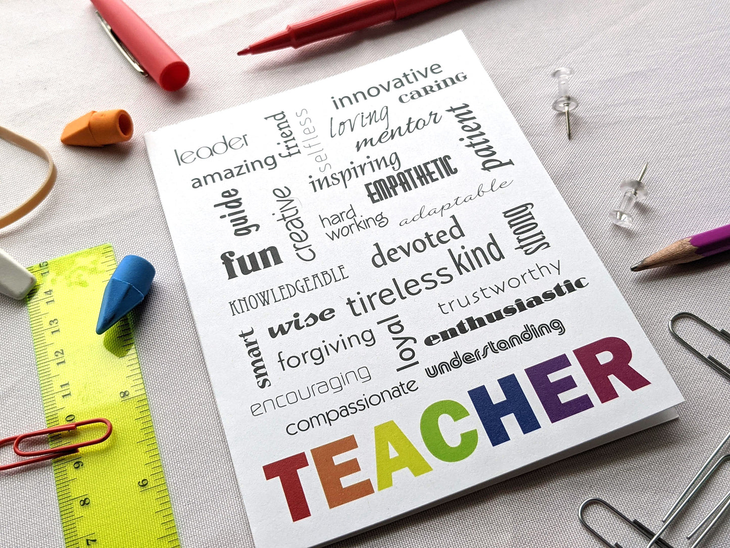 Angled view of a greeting card on a white background surrounded by school supplies.