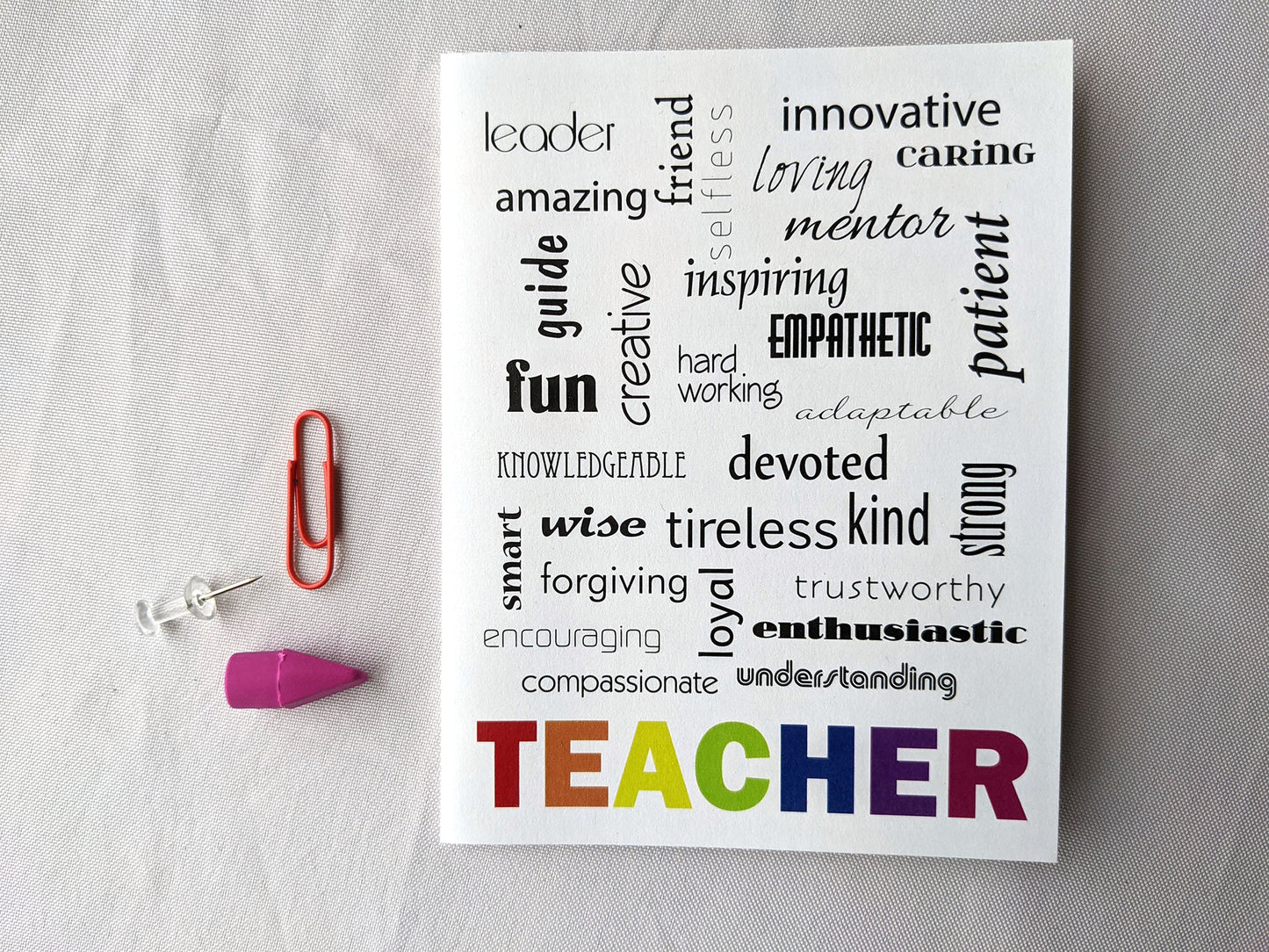 Greeting card on a white background surrounded by a few office supplies.