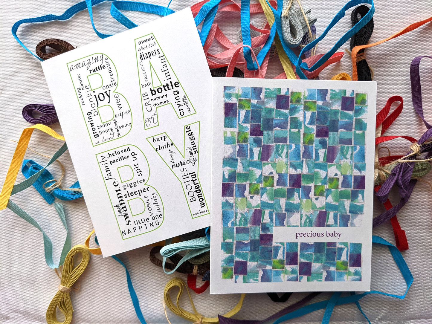 Greeting cards laying on colorful cotton ribbons and a white background.