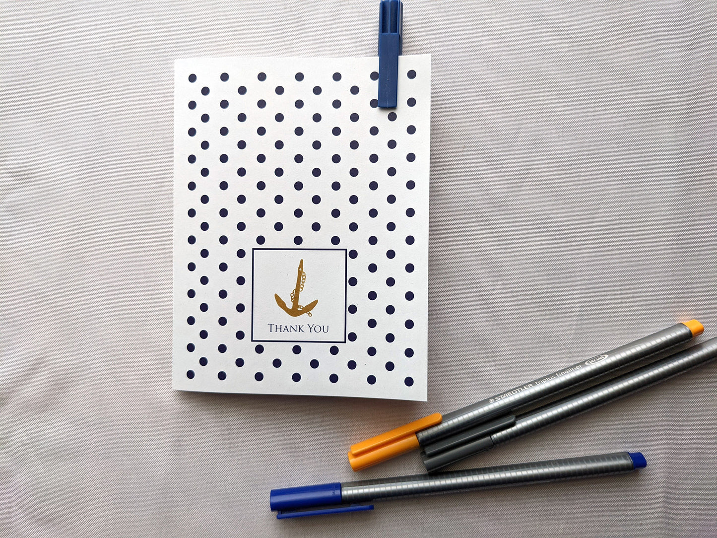 Greeting card laying on a white background with colorful pens.
