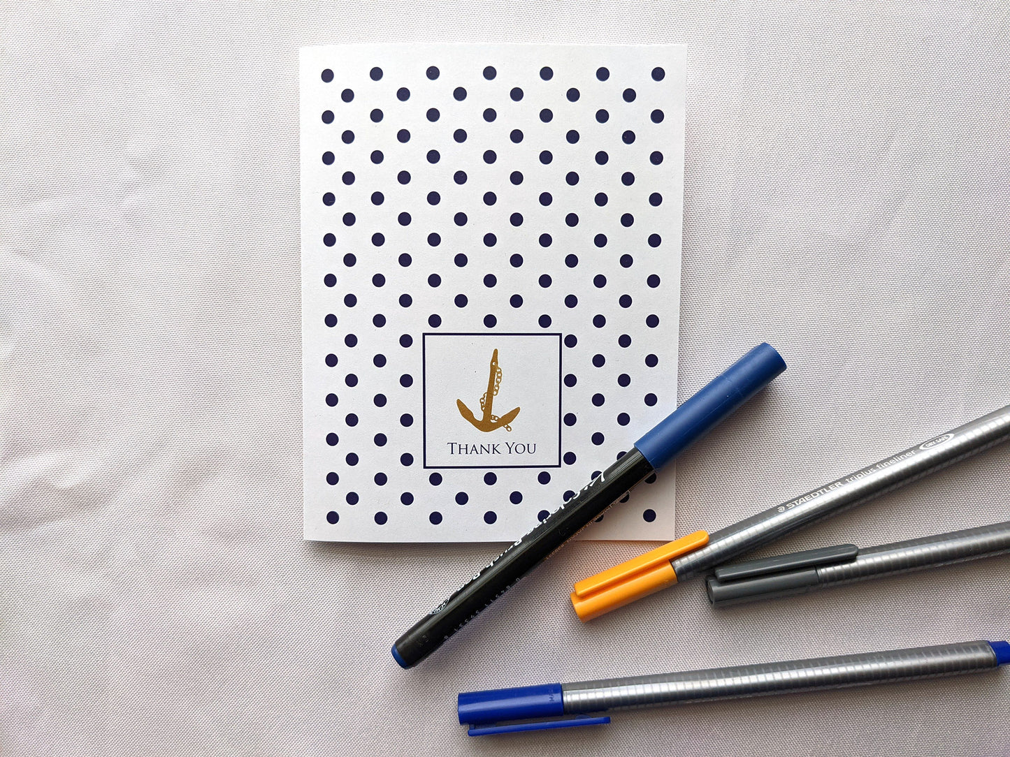 Greeting card laying on a white background with colorful pens.
