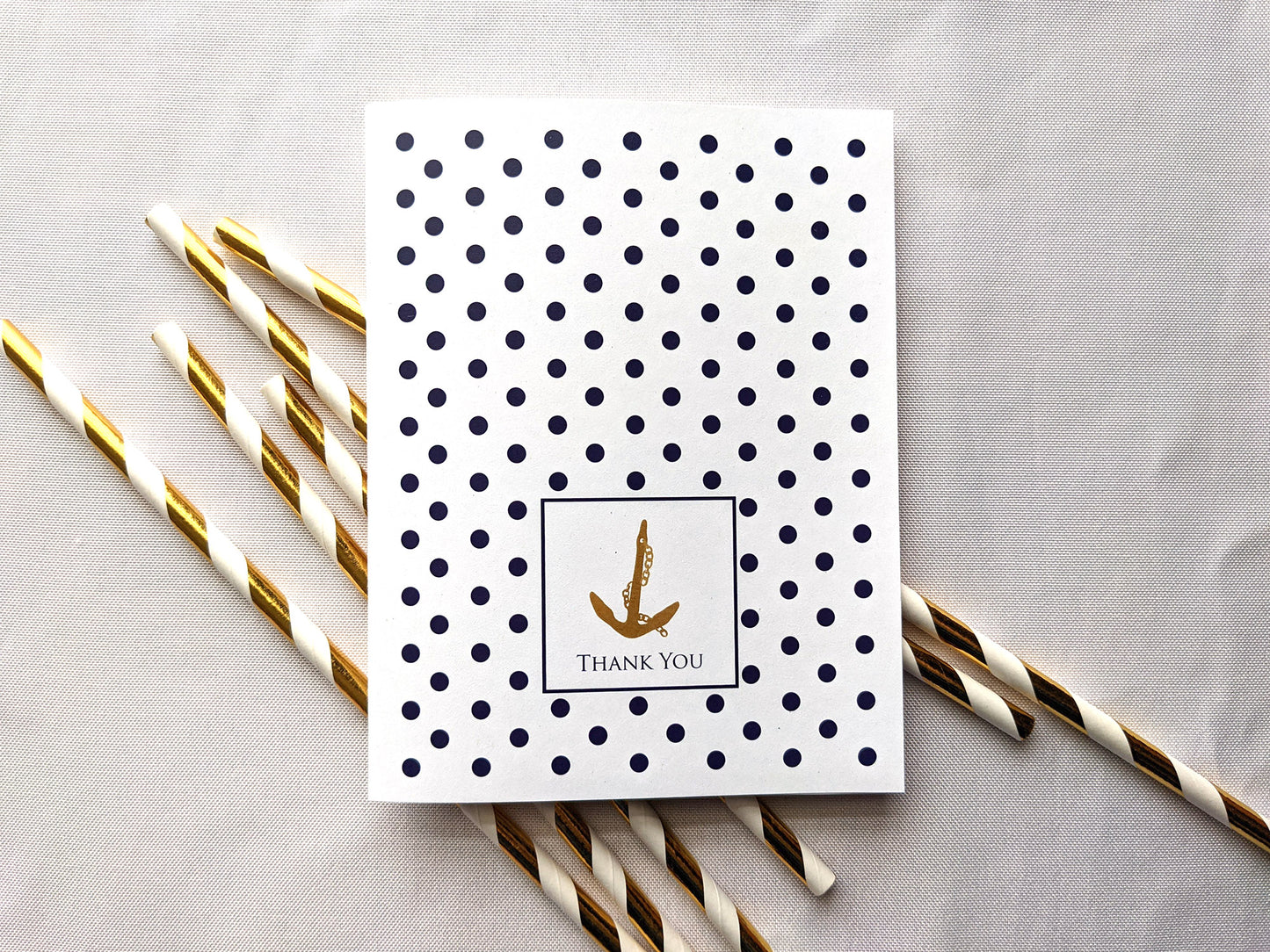 Greeting card laying on paper straws on a white background.