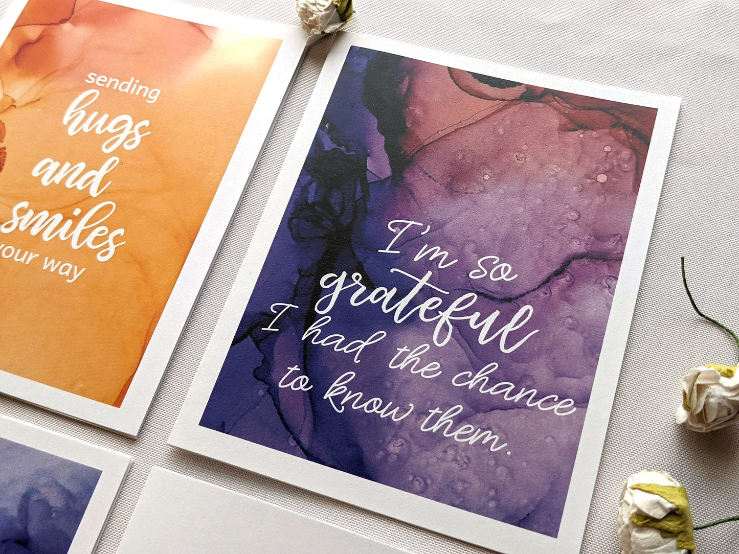 Greeting cards laying on a white background with faux flower buds.