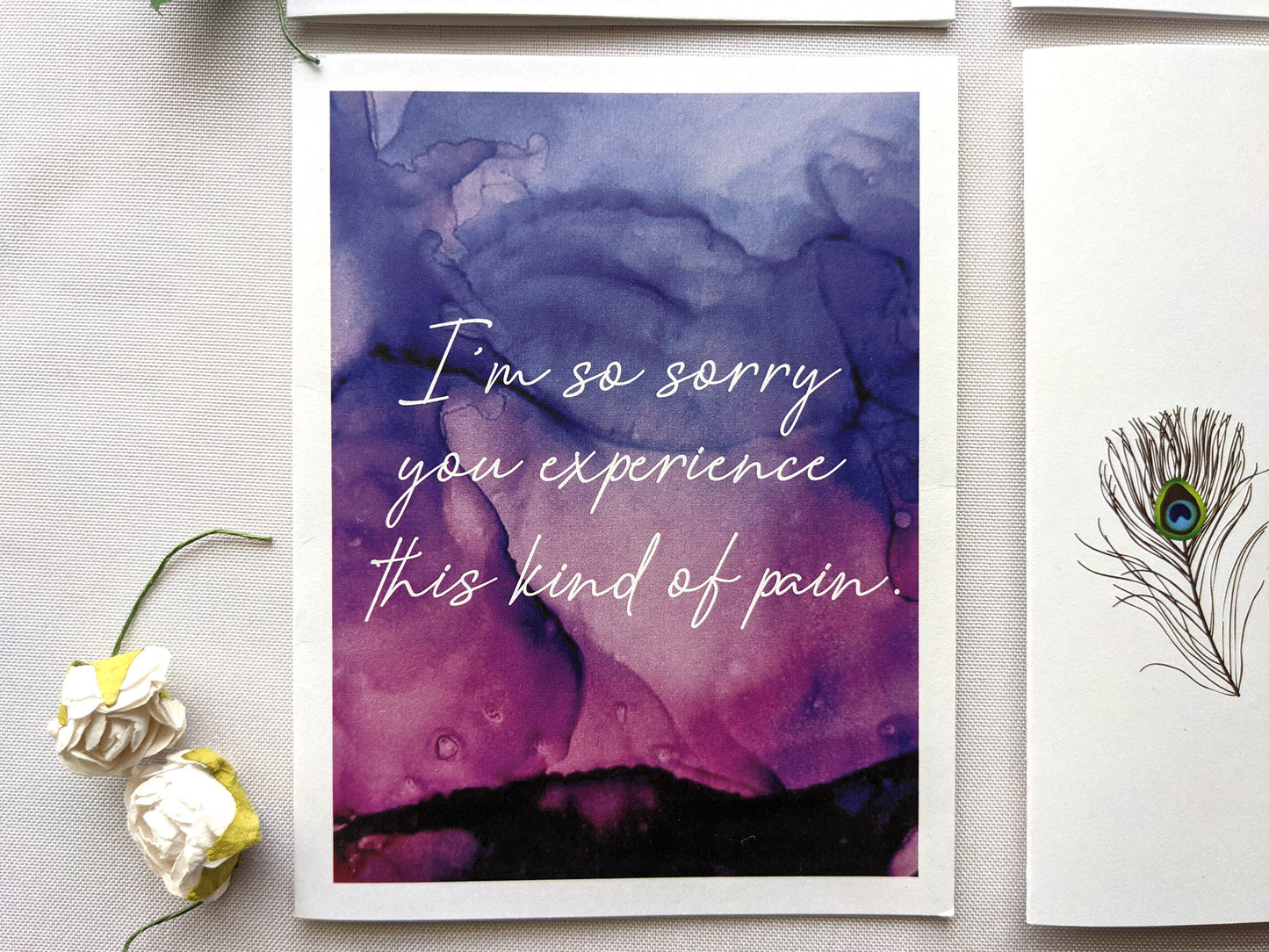 Greeting cards laying on a white background with faux flower buds.