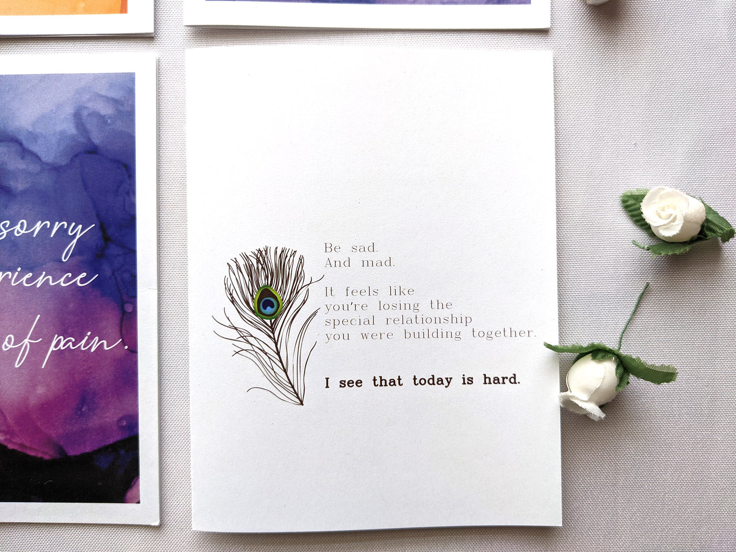 Greeting cards laying on a white background with faux flower buds.