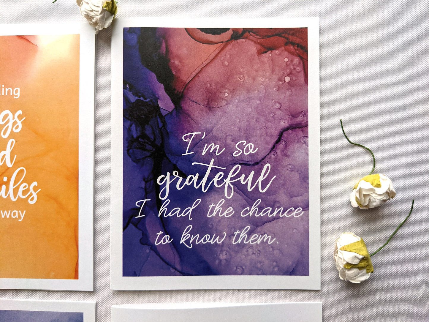 Greeting cards laying on a white background with faux flower buds.