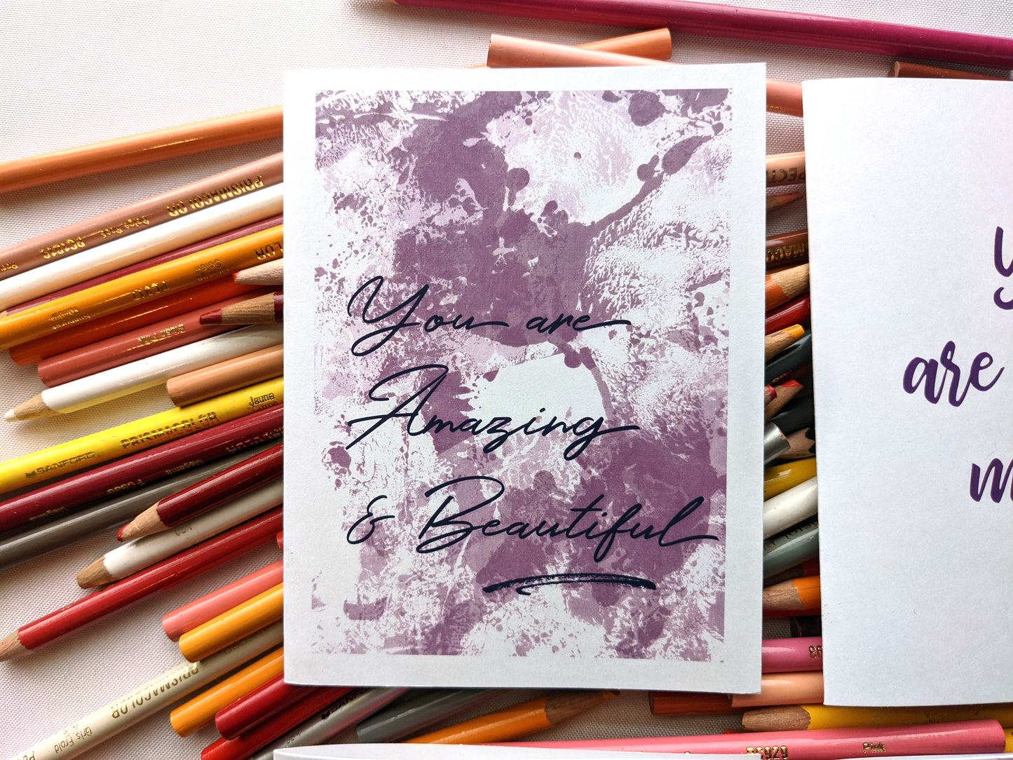 Greeting cards laying on a pile of colored pencils.