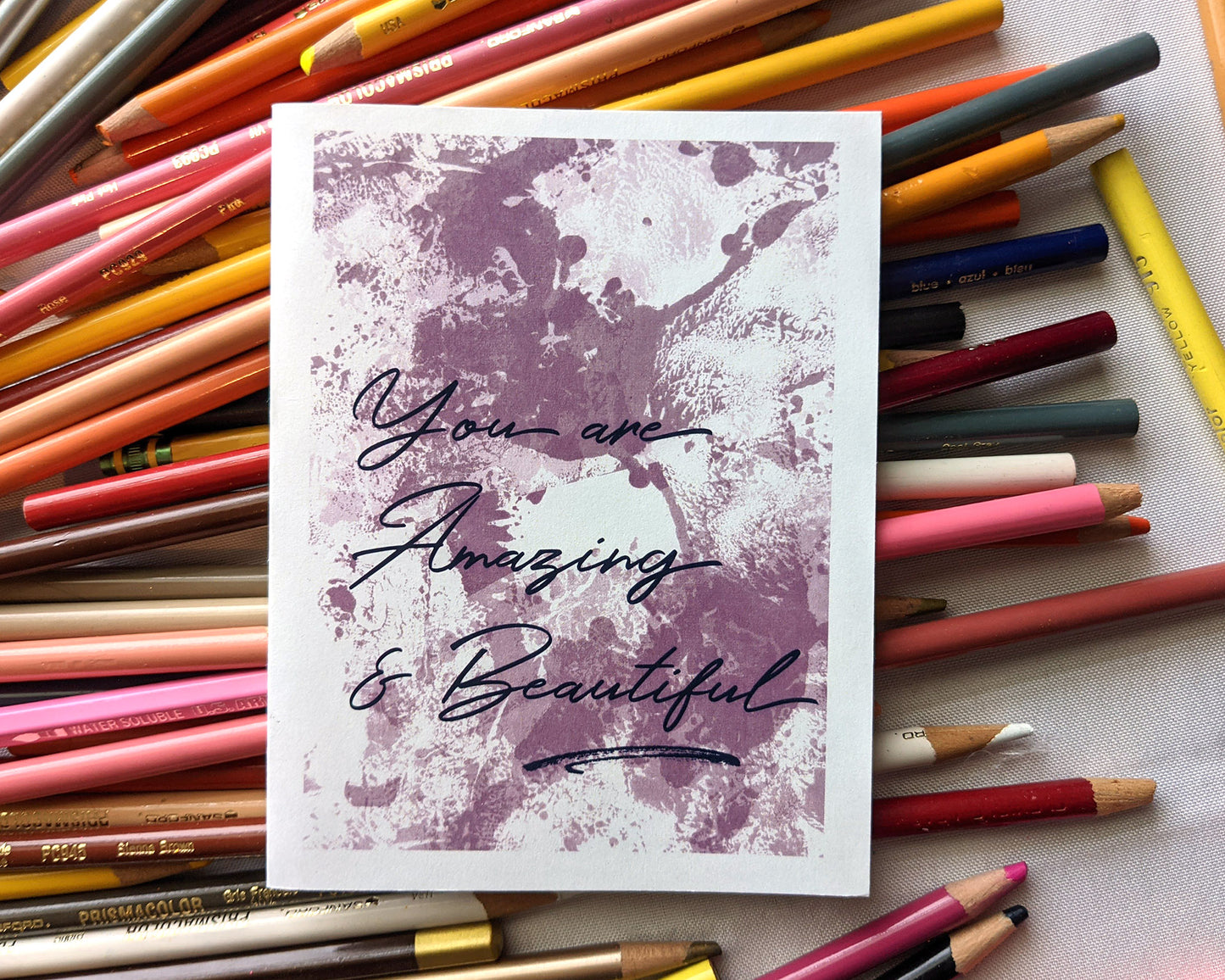 Greeting card laying on a pile of colored pencils.