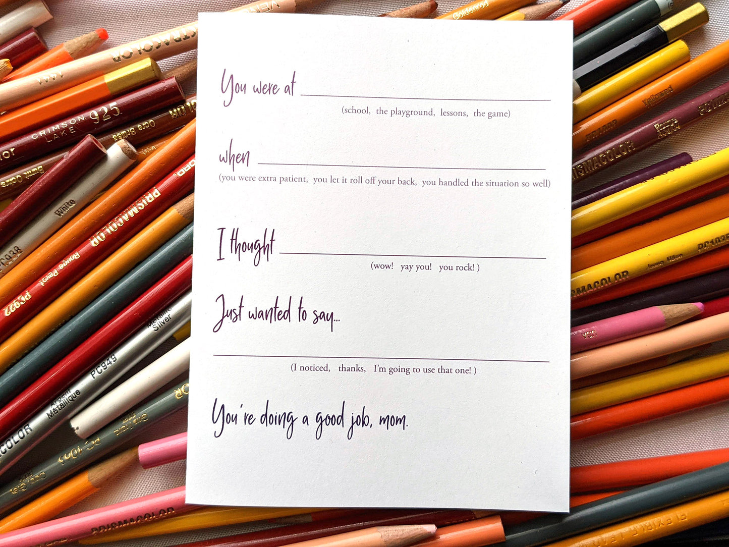 Greeting card laying on a pile of colored pencils.