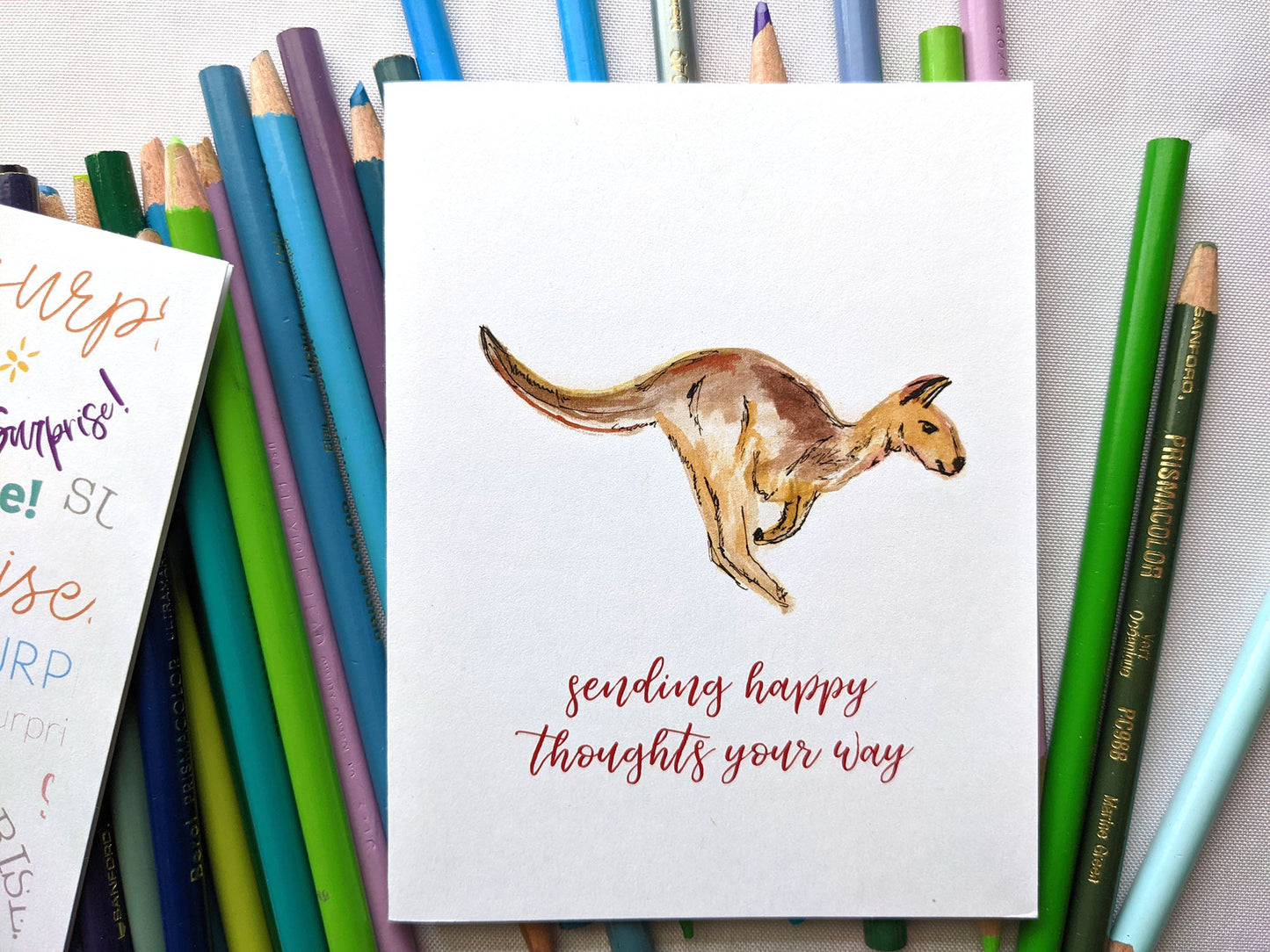 Greeting card laying on a pile of colored pencils.