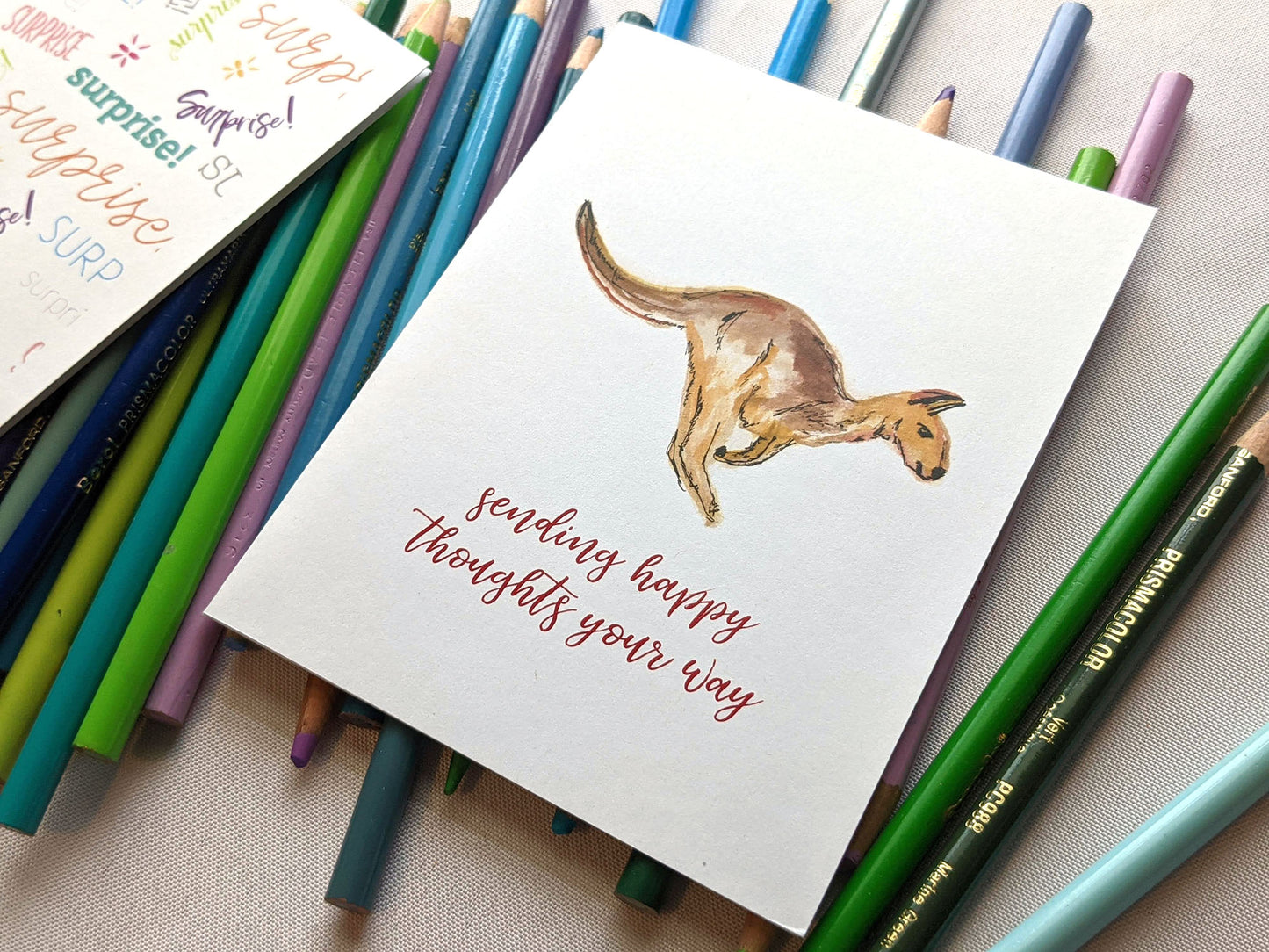 Greeting card laying on a pile of colored pencils.
