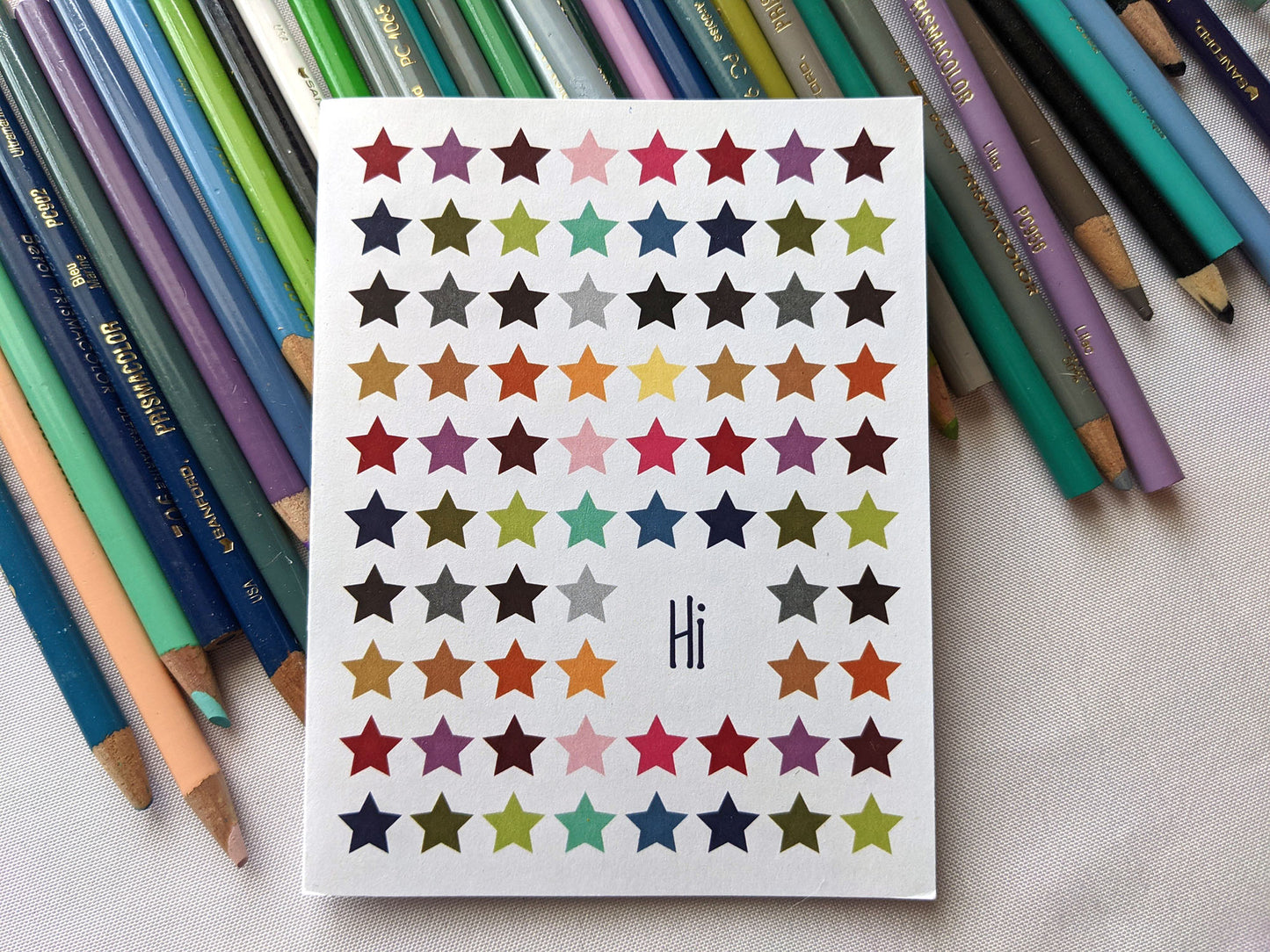 Greeting card laying on a pile of colored pencils.