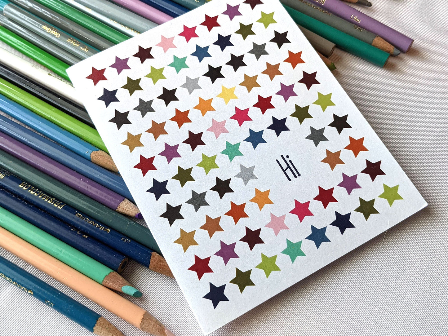 Greeting card laying on a pile of colored pencils.