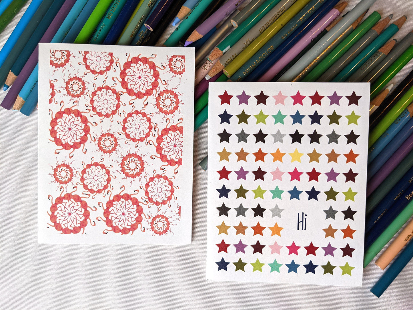 Greeting cards laying on a pile of colored pencils.