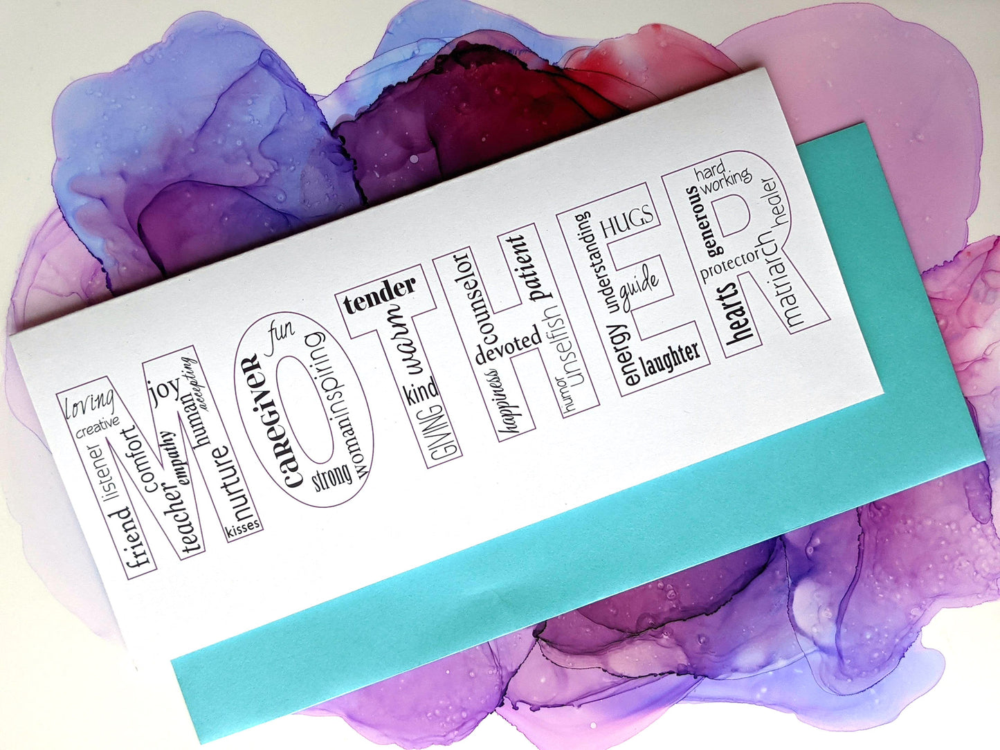 Greeting card and envelope laying on an abstract alcohol ink painting.