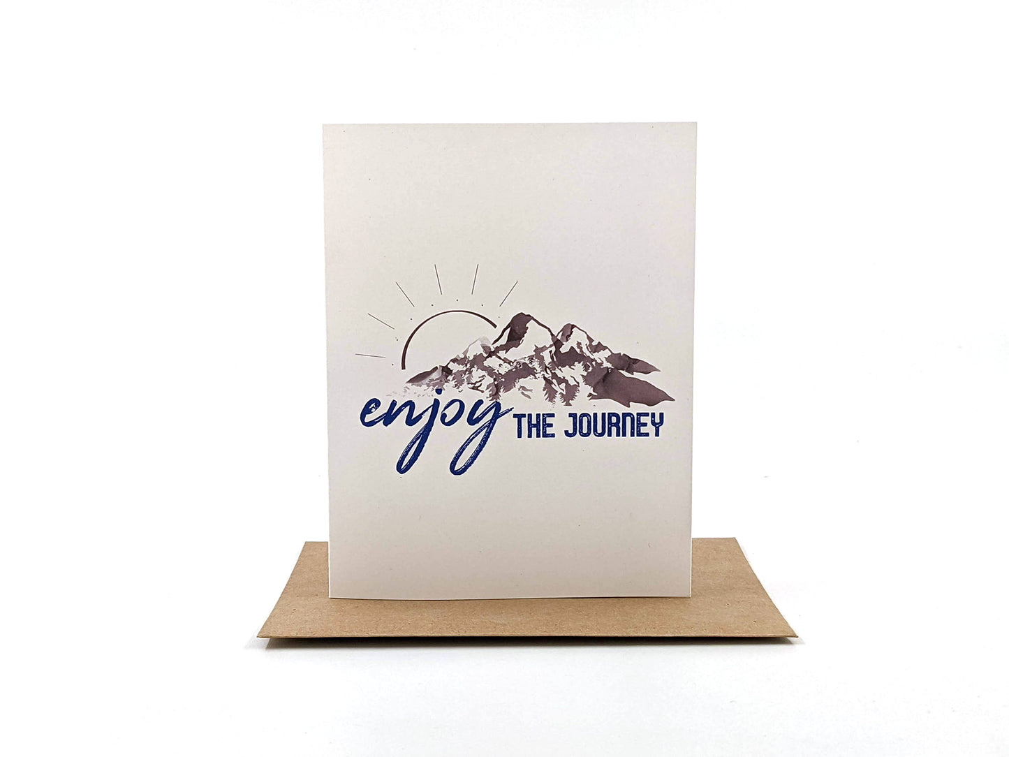 Greeting cards in a kraft box standing upright on top of a kraft envelope against a white background.