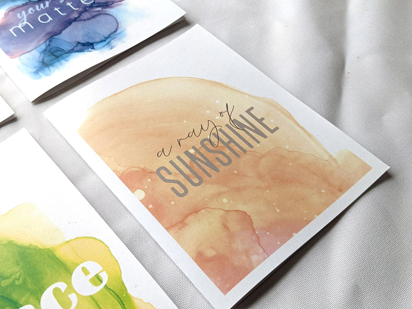 Angled view from above of greeting card next to others from the collection.