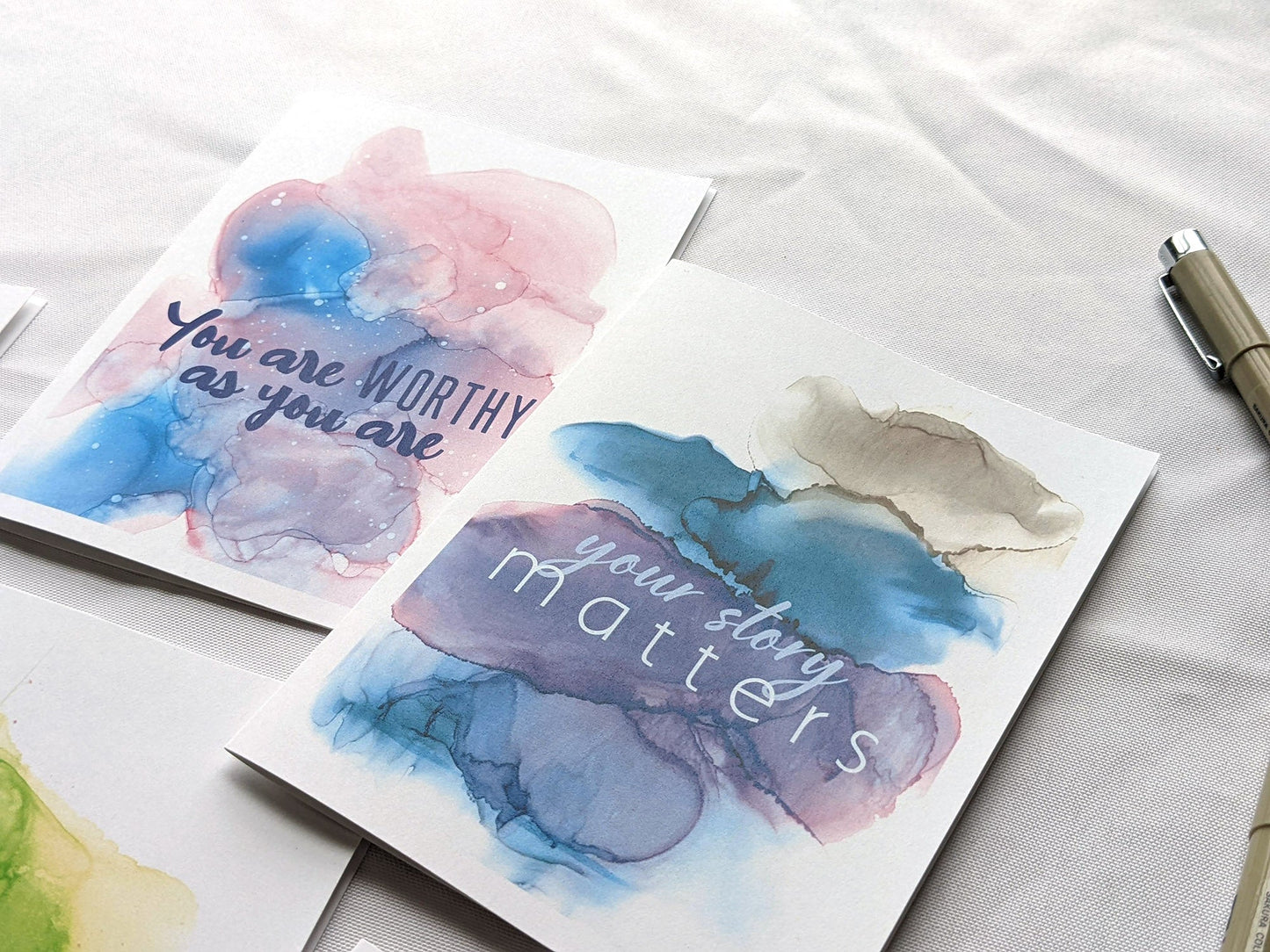 Angled view from above of greeting card next to another from the collection.