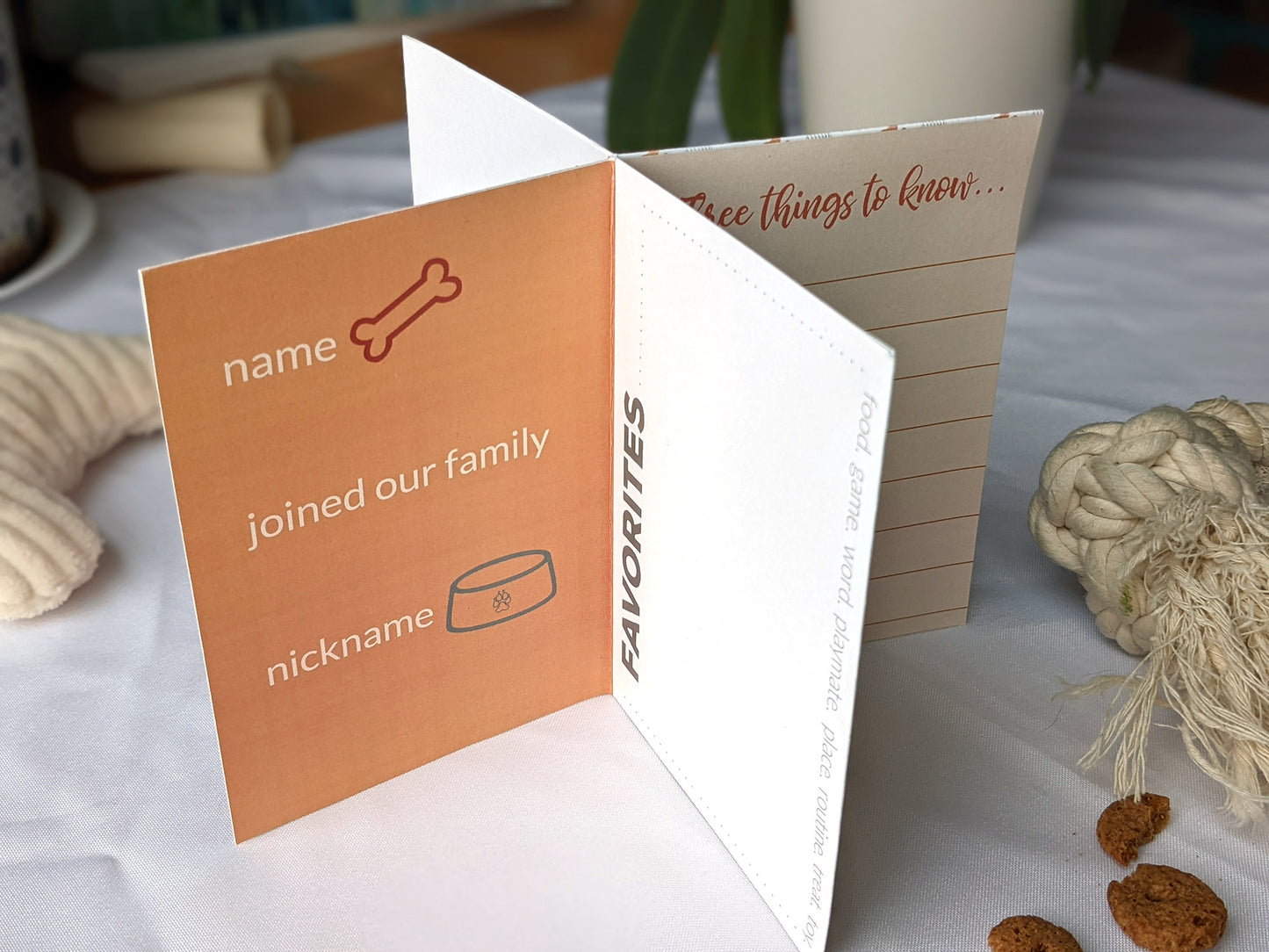 Lifestyle photo of centerpiece with dog toys and treats surrounding it showing the wording on the panels.