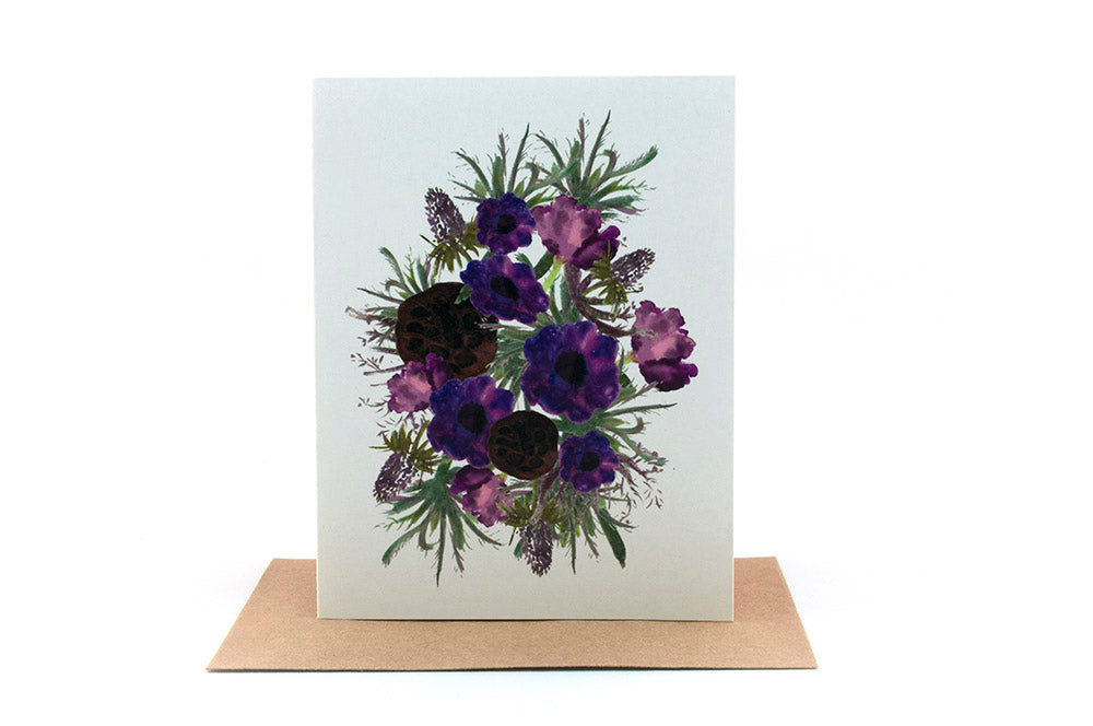 Greeting card standing upright on top of a kraft envelope against a white background.