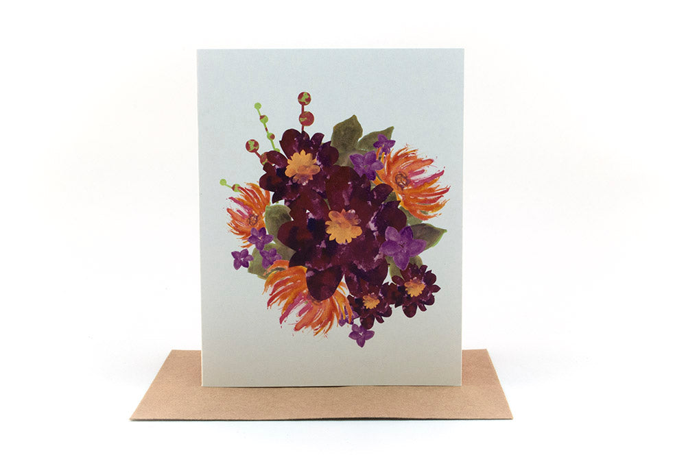 Greeting card standing upright on top of a kraft envelope against a white background.
