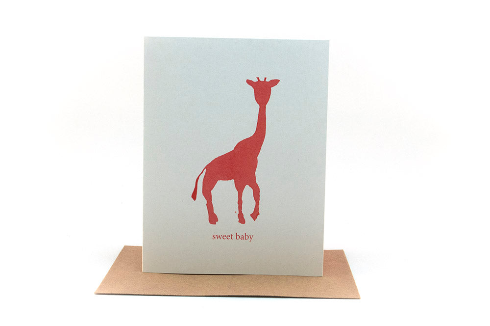 Greeting card standing upright on top of a kraft envelope against a white background.