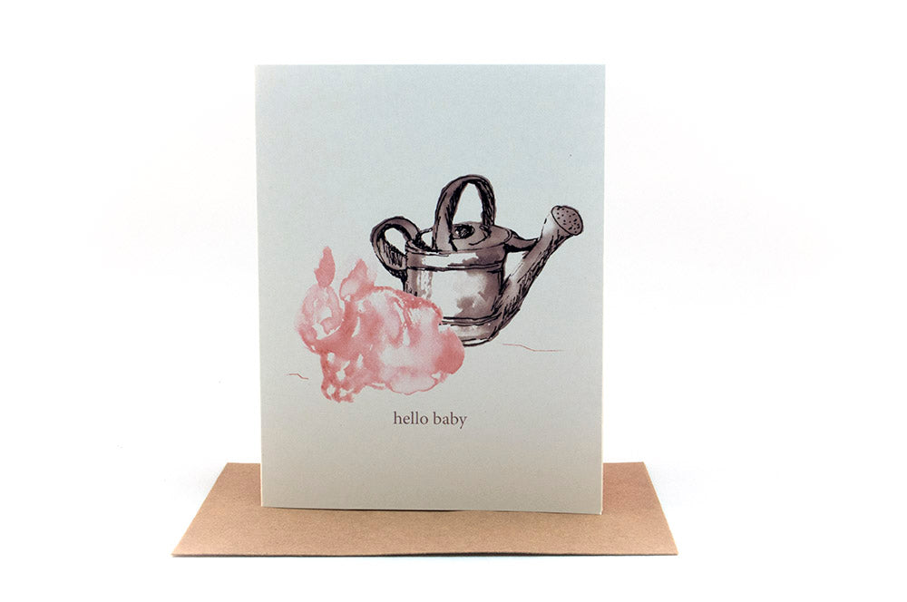 Greeting card standing upright on top of a kraft envelope against a white background.