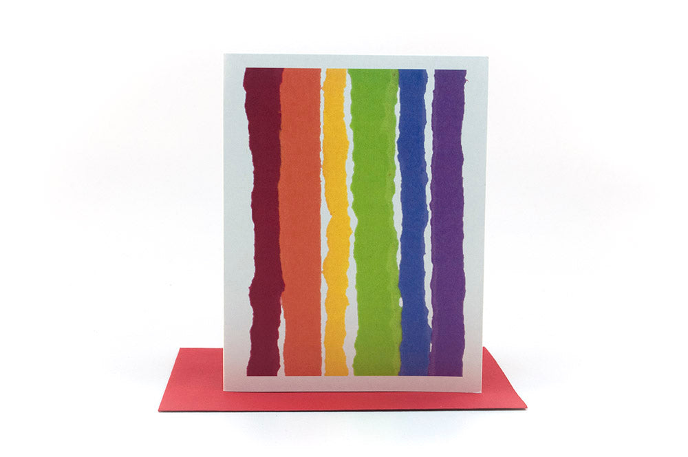 Greeting card standing upright on top of a colorful envelope against a white background.